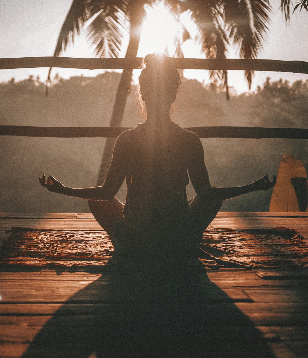 Person sitting tall in a yoga pose at sunset